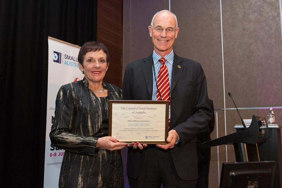 Kate Carnell, Small Business and Family Enterprise Ombudsman, presents CEO of Master Grocers Australia (MGA), Jos de Bruin, with his Small Business Champion award at the Vodafone National Small Business Summit. 