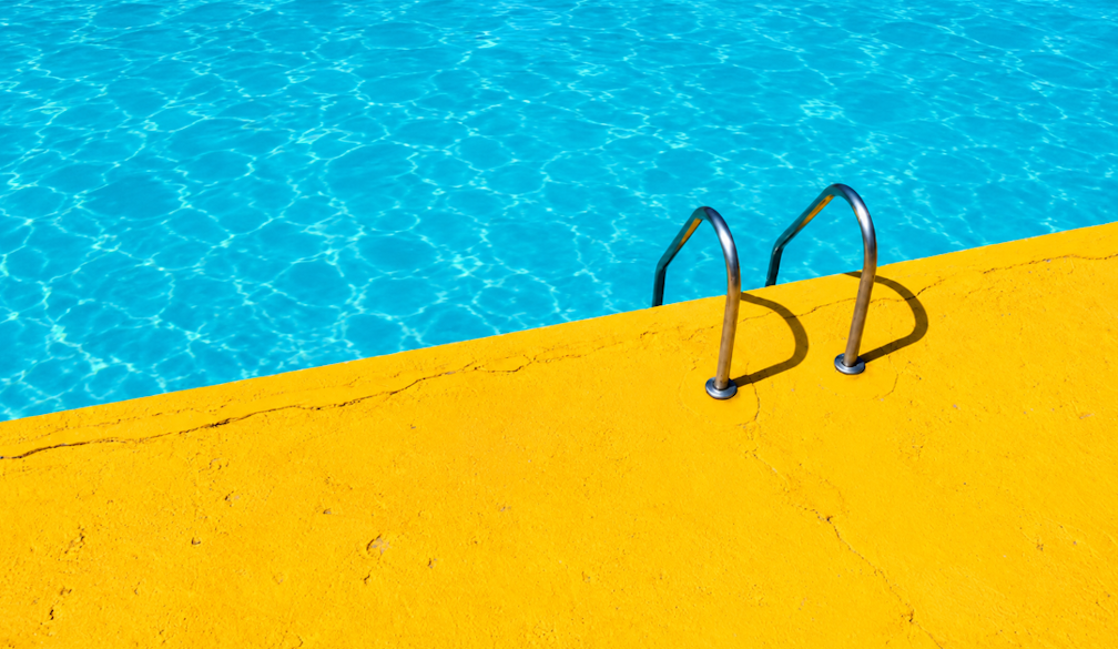 Sunlit Turquoise Pool and Yellow Deck