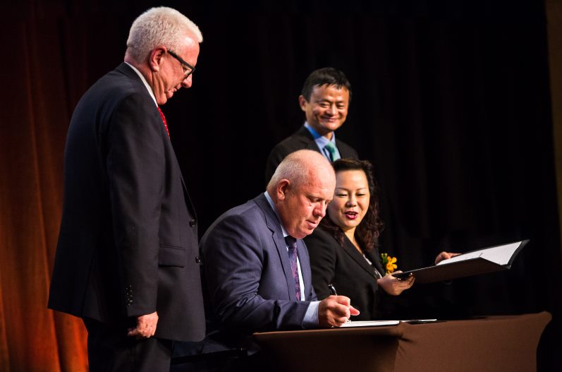 Australia Post Chairman John Stanhope (standing), Australia Post Executive General Manager, Parcel & eCommerce Services & StarTrack CEO Bob Black (seated), Alibaba Group Managing Director (Australia & New Zealand) Maggie Zhou (seated), Alibaba Group Founder Executive Chairman Jack Ma (standing).